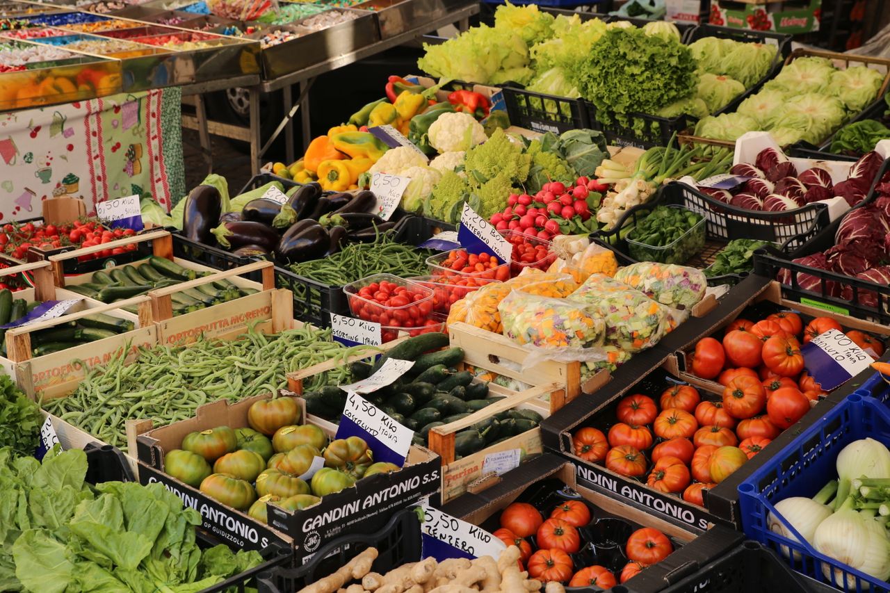 Colorful array of fresh vegetables at an outdoor market stall, showcasing a variety of seasonal produce.